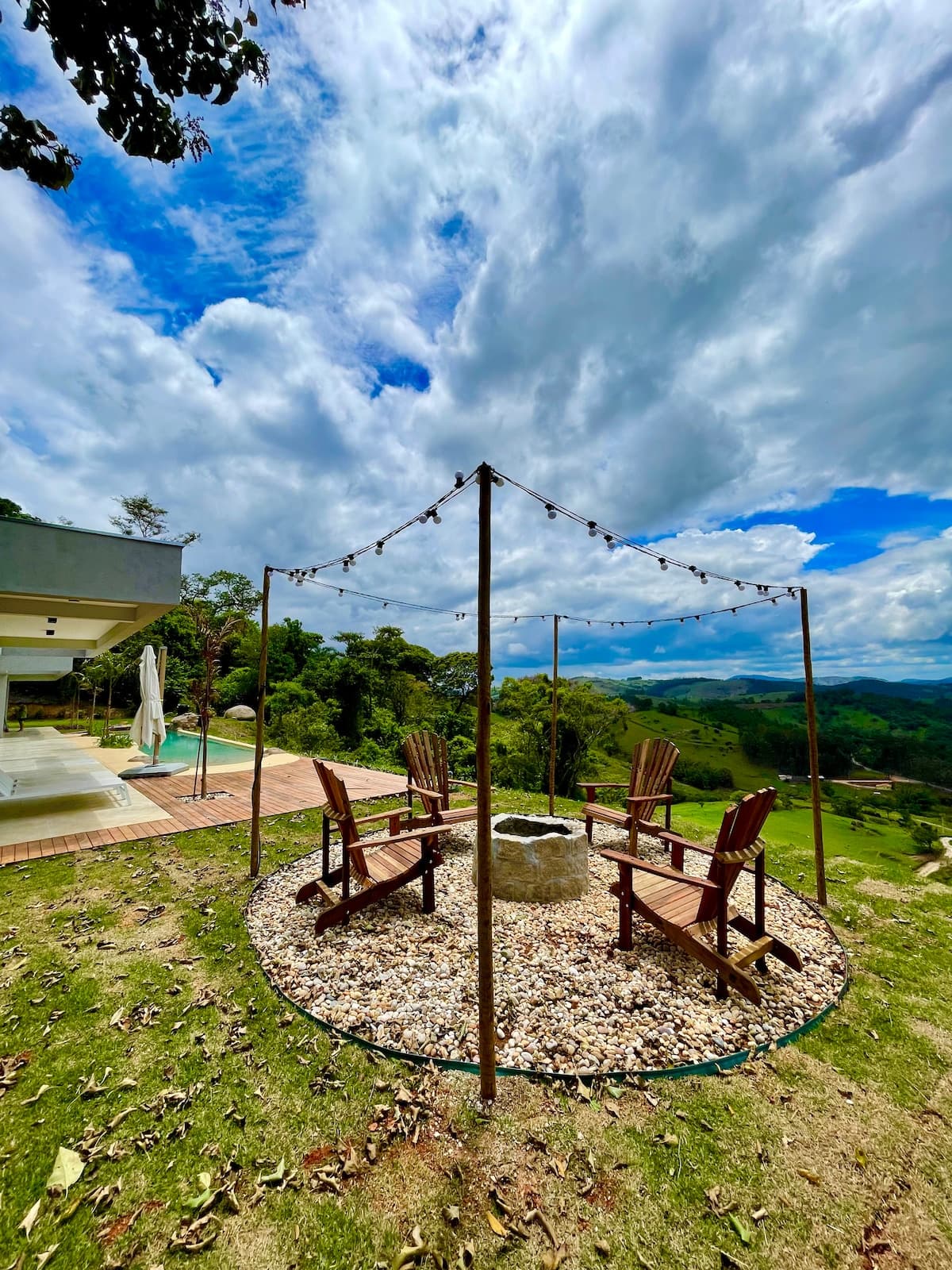 Cadeiras ao redor do fogo de chão com vista ampla para a serra